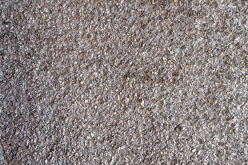 gray wall with protruding small stones. rough granular surface texture
