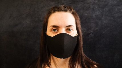 portrait of a woman, young woman wearing a hygienic facial medical mask to prevent infection, illness or flu, and 2019 nKoV. Grey background. Protection against diseases, coronaviruses.