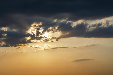Fototapeta na wymiar Nice sunset with dramatic clouds. Sunbeam through a thundercloud