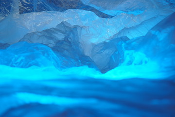 A Photo Depiction of a Fantasy Mountain Region, Showing a Scrunched Plastic Sheet with a Range of Blurred Blue Ridge Peaks. 