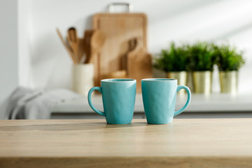 Wooden table in a sunny kitchen in the morning light during breakfast