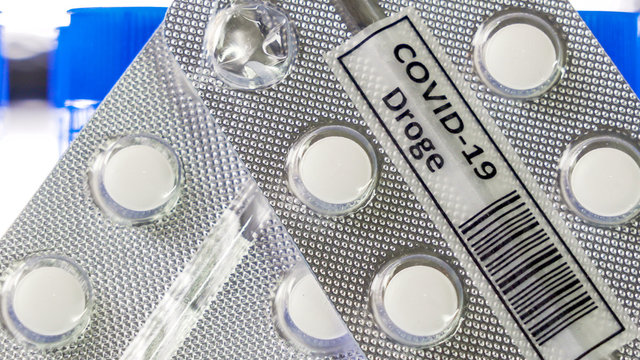 Closer look of the white drug Covid-19 Droge written in German tablet for coronavirus