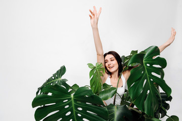 Young woman on a white background with a monstera flower. © Наталья Котковец