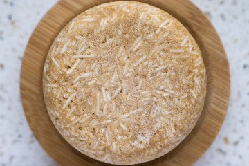 Top view round soap on a wooden soap dish.