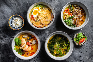 Assorted traditional Asian soups. Miso, Ramen, Tom Yam, Pho Bo. Black background. Top view