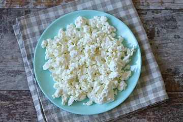 Selective focus. Fresh homemade cottage cheese on a plate.