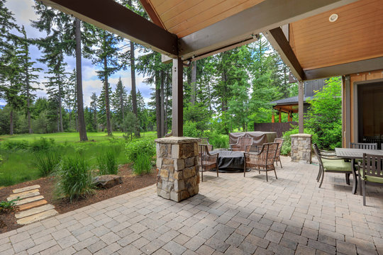 Beautiful Back Yard Stone And Brick Patio With BBQ Grill And Luxury Futniture.