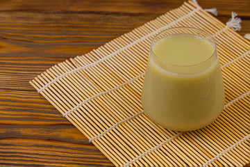 Green drink in a beautiful glass on wooden table