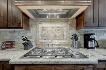 Cooking range large new luxury with natural stone backsplash and modern hood above