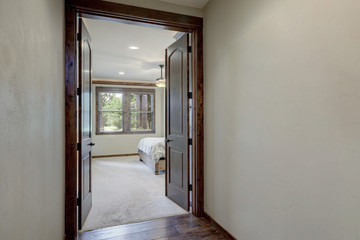 Empty grey hallway walls with open door to the bedroom.