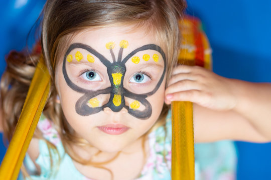 Party Little girl with painting face as a butterfly or bee.