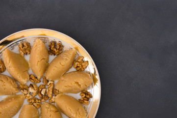 Turkish famous traditional homemade flour halva served with walnut in plate on rustic background, turkish dessert for holy night or funeral