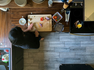 overhead view of woman cooking in real messy kitchen