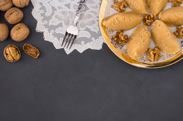 Turkish famous traditional homemade flour halva served with walnut in plate on rustic background, turkish dessert for holy night or funeral