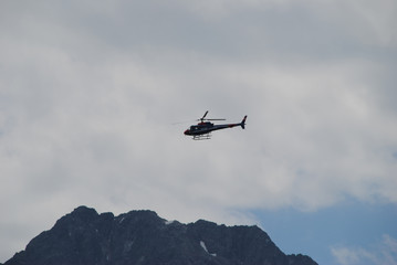 Fototapeta na wymiar Polizeihubschrauber über den Bergen