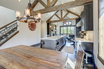 Amazing dining room near modern and rustic luxury kitchen with vaulted ceiling and wooden beams,...