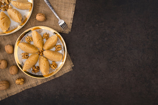 Turkish famous traditional homemade flour halva served with walnut in plate on rustic background, turkish dessert for holy night or funeral