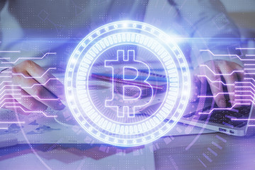 Crypto currency theme hologram with businessman working on computer on background. Concept of blockchain. Double exposure.