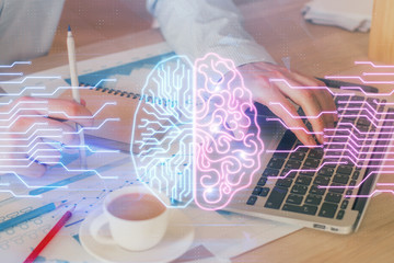 Businessman with computer background with brain theme hologram. Concept of brainstorm. Multi...
