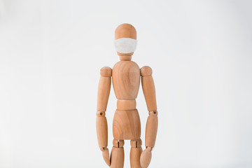 Wooden mannequin in medical mask on white background. Concept quarantine photo.