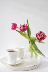 Three red terry tulips in a round vase