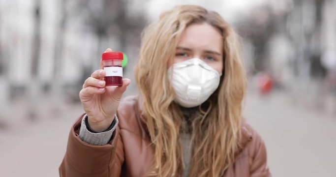 Do a test for the coronavirus! Take care of yourself! Young woman hold sample tube testing for presence of coronavirus. Tube containing a swab testing for COVID-19.
