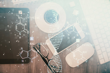 Double exposure of DNA drawing over table with phone. Top view. Science education concept.