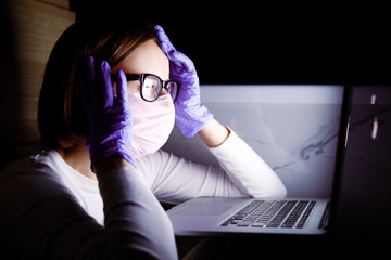 Woman in medicine mask and latex gloves reading news in social media on notebook, feeling panic about covid-19 coronavirus. Hypochondria and fear of gems concept. Prevention of infection spread