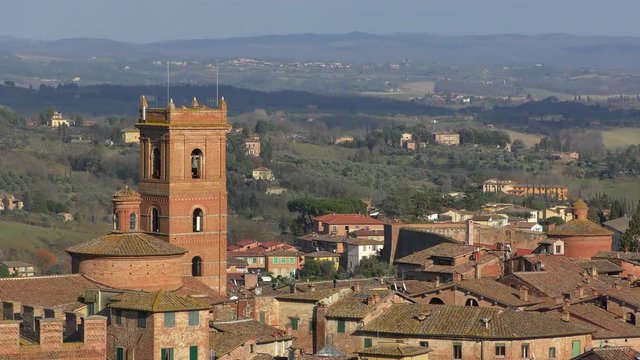 The view from the heights of the rooftops of ancient Siena and the beautiful hills in the surrounding area. Tuscany, Italy.