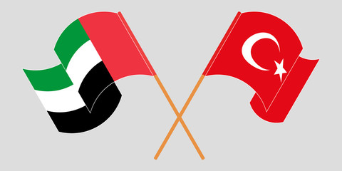 Crossed and waving flags of Turkey and the United Arab Emirates