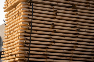 Warehouse for sawing boards on a sawmill outdoors. Timber mill, sawmill. Storage of planed wooden boards. Piles of wooden boards in the sawmill. Planking. Industry.