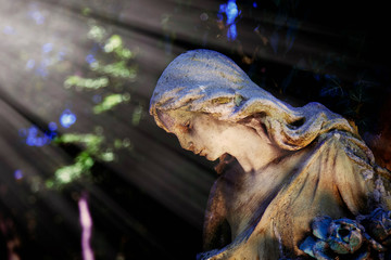 Wonderful angel with sweet facial expression in the sunlight. Fragment of ancient stone statue.