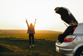 Traveling young girl looking at the sunset. Concept of freedom and active lifestyle, adventure, travel.