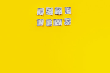 Paper art banner on yellow backdrop in style zine wiht words fake news.