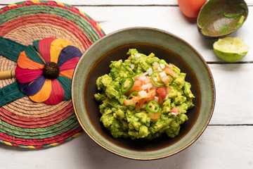 Mexican guacamole with tomato and serrano pepper on white background