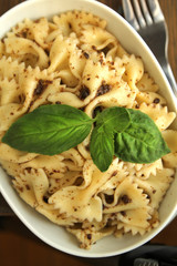 Farfalle pasta with fresh pesto serve in a white bowl