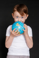 Face of a mask-wearing boy with fear in the eye Close-up on a gray background. Coronavirus and Air pollution concept. COVID-19 child on black background.