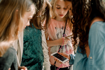 Friends using mobile phone while standing in corridor