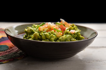 Mexican guacamole with tomato and serrano pepper on white background