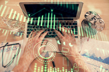 Double exposure of man's hands typing over computer keyboard and tech theme hologram drawing. Top view. Technology concept.