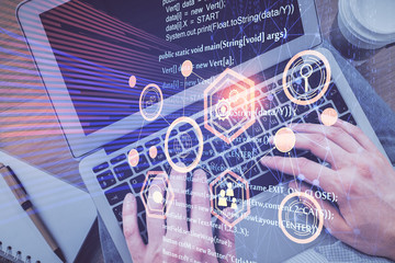 Multi exposure of man's hands typing over computer keyboard and data theme hologram drawing. Top view. Technology concept.