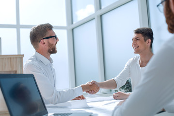 business people shaking hands in a bright office.