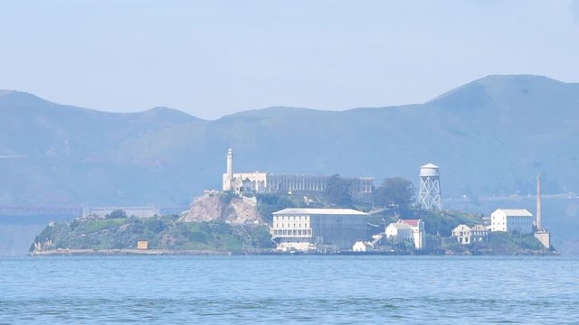 HD video zooming in on Alcatraz Island, 1.25 miles away from San Francisco on a hazy day. The islands facilities are managed by the National Park Service and it is open to the public for tours.