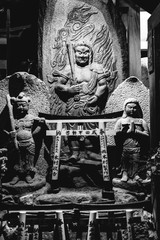 Stone statue of shinto guardians, and little torii gates, Fushimi Inari, Kyoto (in black and white)