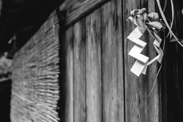 Shide (Shinto zigzag paper) at closed wood door in Kurama, Japan (in black and white)