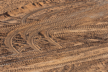 Texture of tracks and wheels traces on the sand of a construction site.