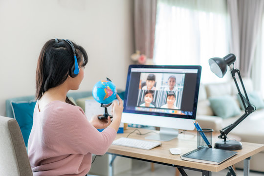 Asian woman teacher teaching geography via video conference e-learning and cheerful elementary school student looking at globe, Homeschooling and distance learning ,online ,education and internet..