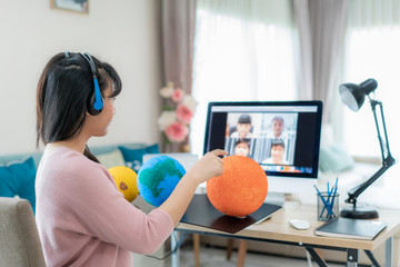Asian woman teacher teaching solar system via video conference e-learning and cheerful elementary...