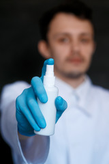 Close up view of female physician hands showing a personal antiseptic or sanitizer. Covid-19 protection measures. Doctor in white medical gown at clean white background