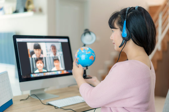 Asian woman teacher teaching geography via video conference e-learning and cheerful elementary school student looking at globe, Homeschooling and distance learning ,online ,education and internet..